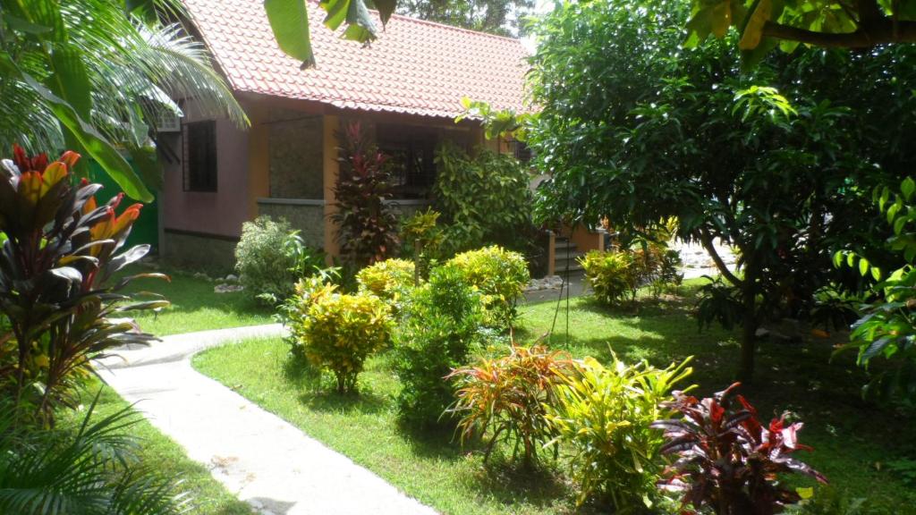 a garden in front of a house with plants at Bungalow auf Sibuyan am Strand nahe Cresta de Gallo in Azagra