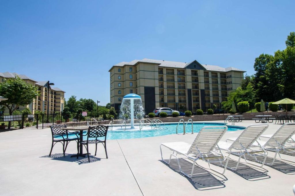 a pool with chairs and a table and a fountain at Abundantly Blessed Mountain View 3604 in Pigeon Forge