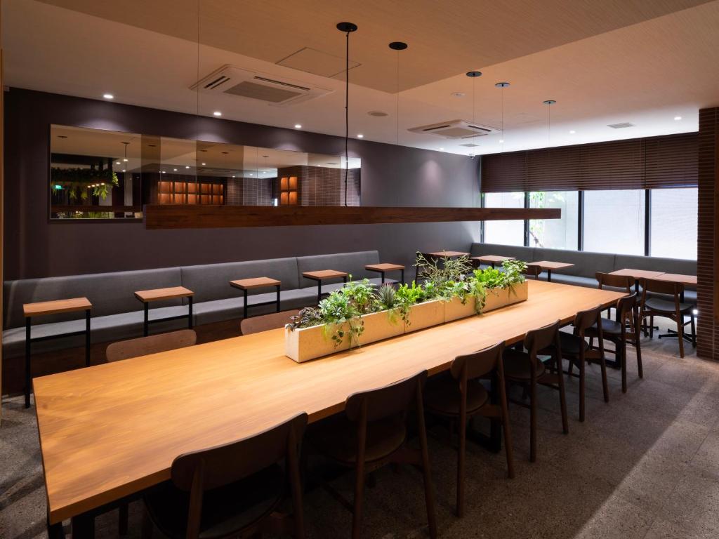 a dining room with a long wooden table and chairs at Super Hotel Premier Kanazawaeki Higashiguchi in Kanazawa