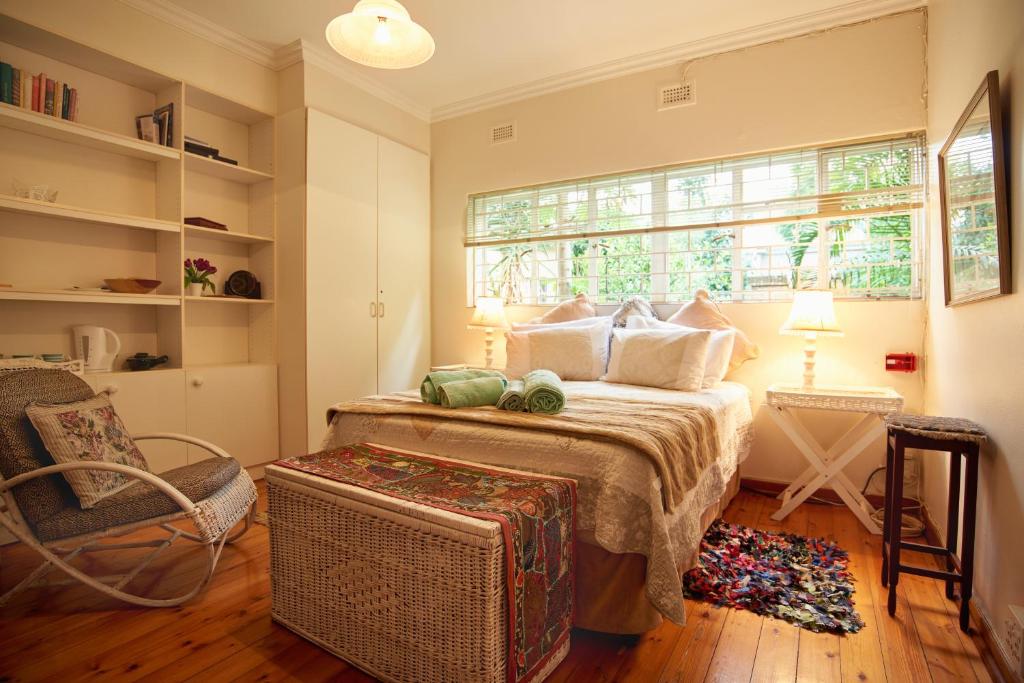 Pretoria的住宿－800@Merton，一间卧室配有一张带窗户和椅子的床