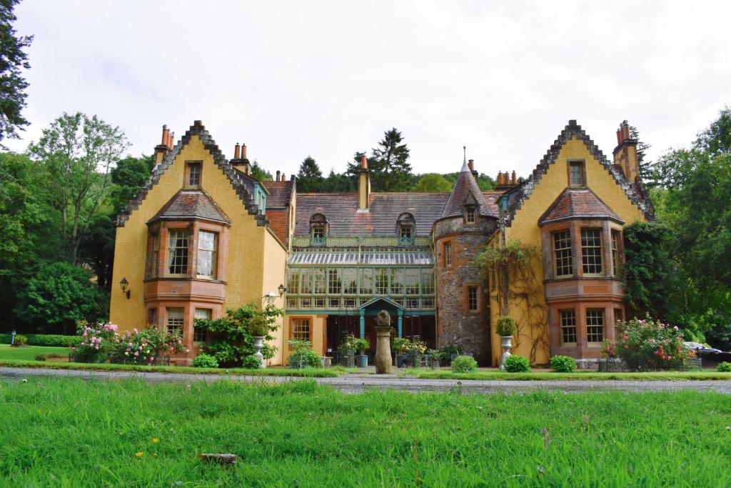 an old house with a green lawn in front of it at Leithen Lodge in Innerleithen