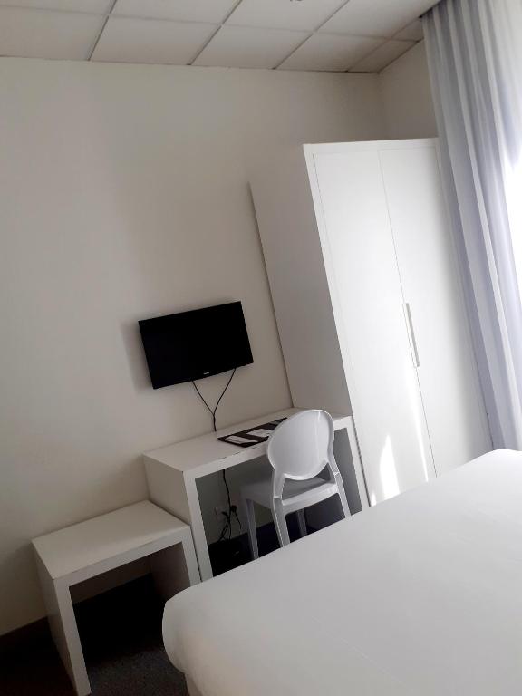 a bedroom with a desk with a computer and a tv at Hôtel P.L.M. in Cannes