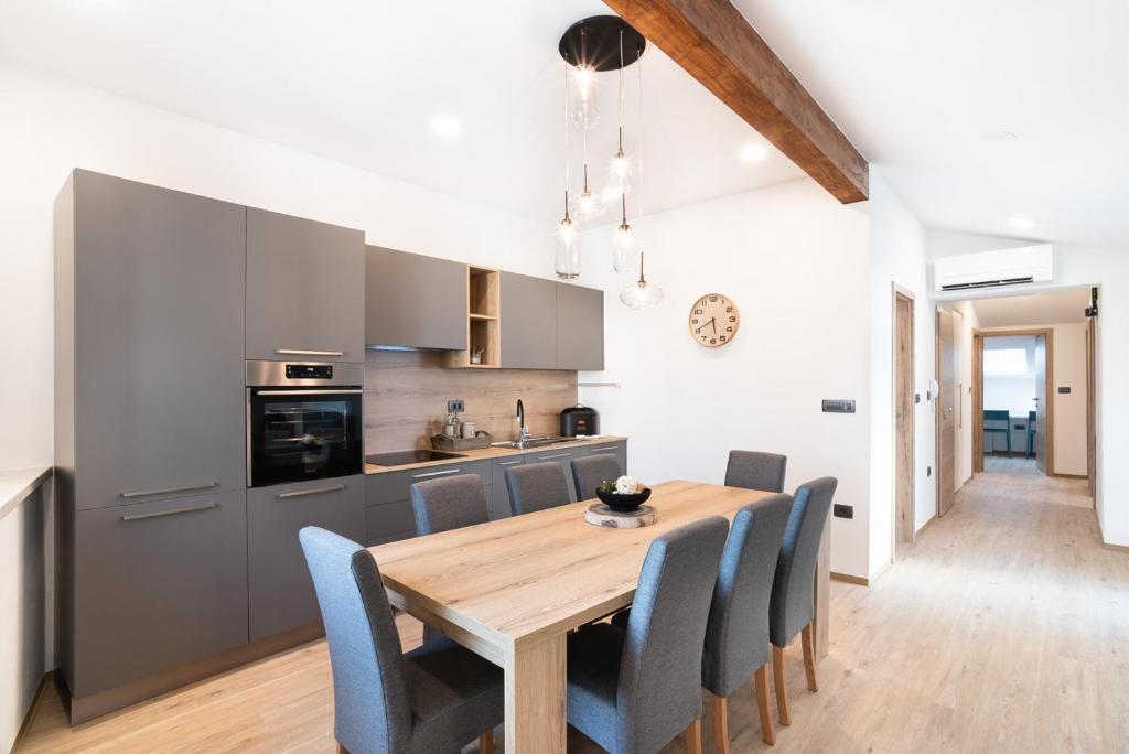 a kitchen and dining room with a wooden table and chairs at CAPRARIA appartments in historic center, with private parking in Koper