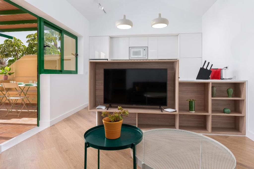 a living room with a tv and a table and a chair at Apartamento moderno en Costa Calma in Costa Calma