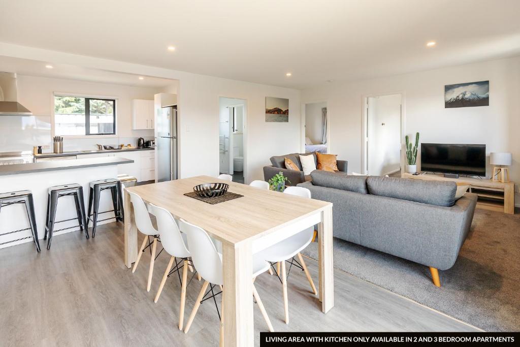 a kitchen and living room with a table and a couch at The Willows Wanaka in Wanaka