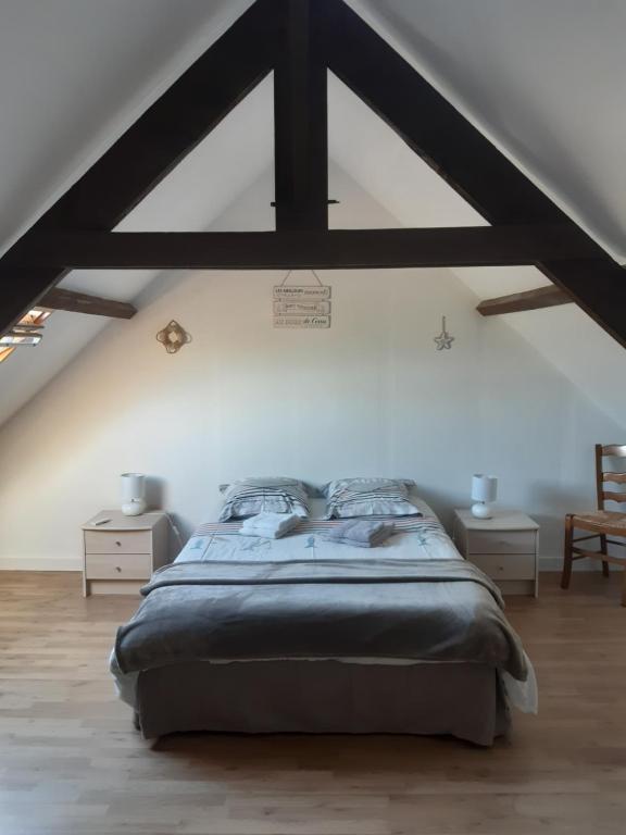 sypialnia z dużym łóżkiem na poddaszu w obiekcie Les Greniers De Blanche w mieście Le Vivier-sur-Mer
