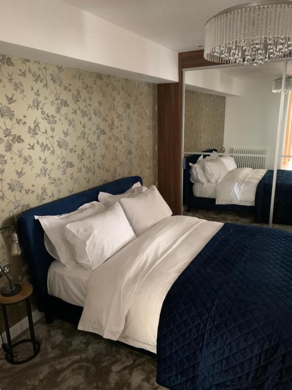 ein Schlafzimmer mit einem großen Bett und einem Spiegel in der Unterkunft Mitre Court Holiday Home in Plymouth