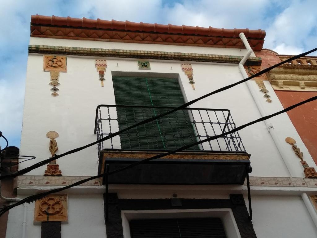 un edificio con finestra con persiane verdi di CA LA ROSALIA a Rodonyà