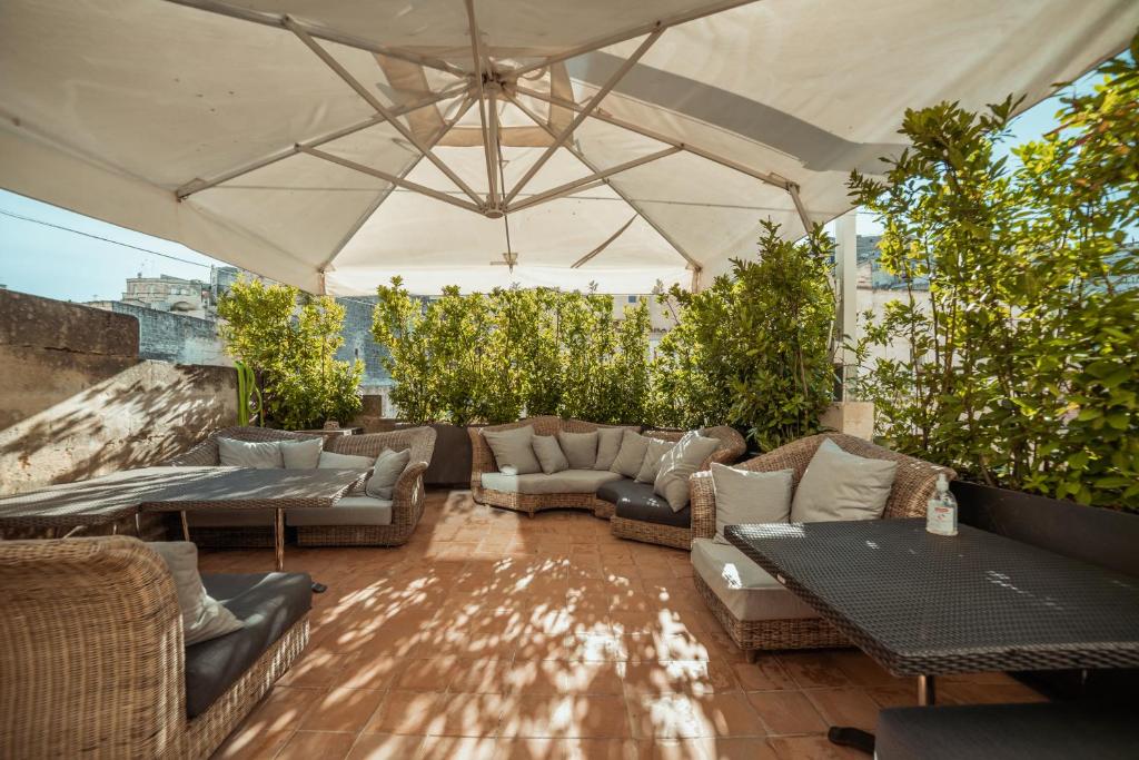 patio z kanapami i stołami oraz białym namiotem w obiekcie Gradelle San Nicola w mieście Matera