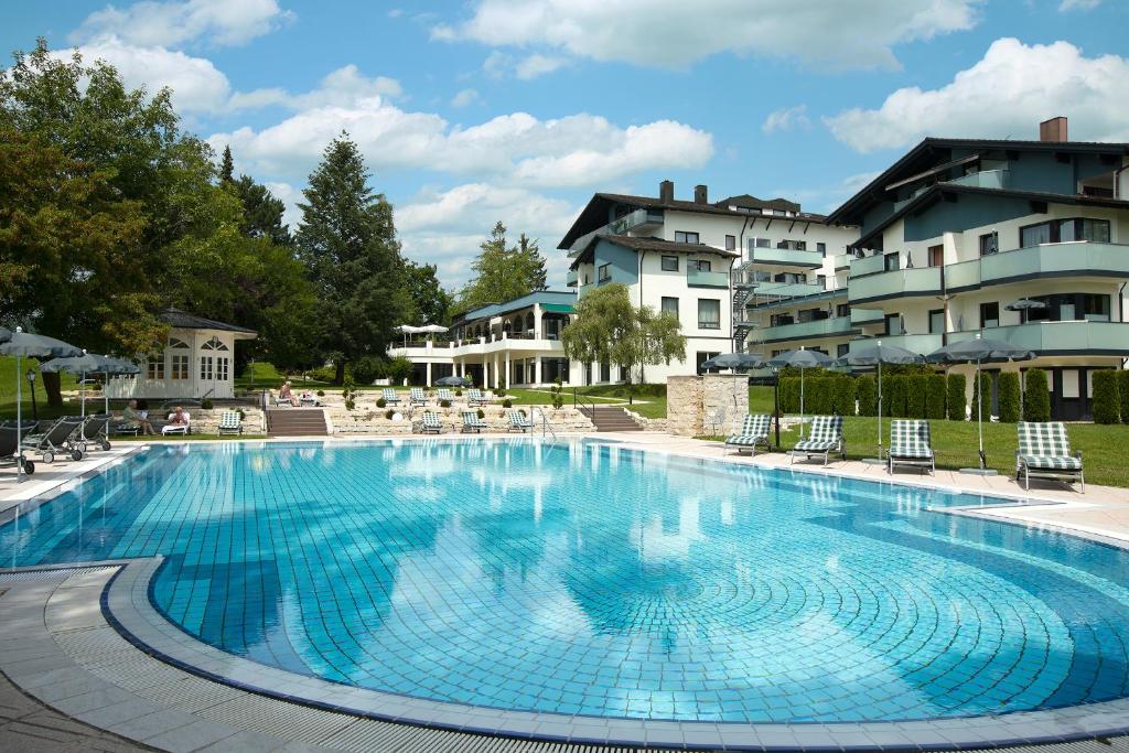 a large swimming pool in front of a hotel at Hotel Tanneck in Bad Wörishofen