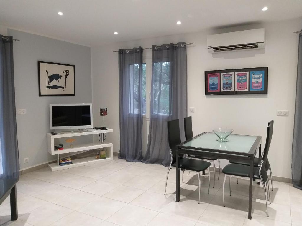 a dining room with a table and chairs and a television at Elsanais in Figari