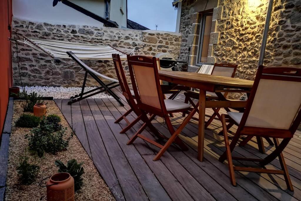 une table et des chaises en bois sur une terrasse en bois dans l'établissement LA BICOQUE A TITI, au Croisic