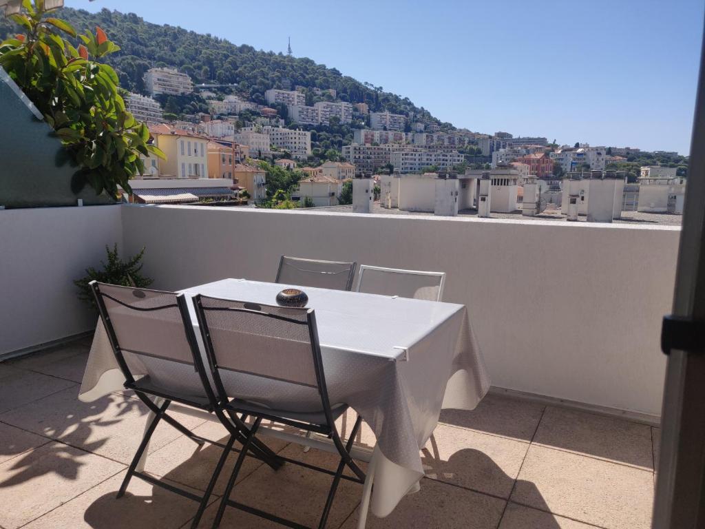 ニースにあるAppartement Terrasse Niceの白いテーブルと椅子、景色を望むバルコニー