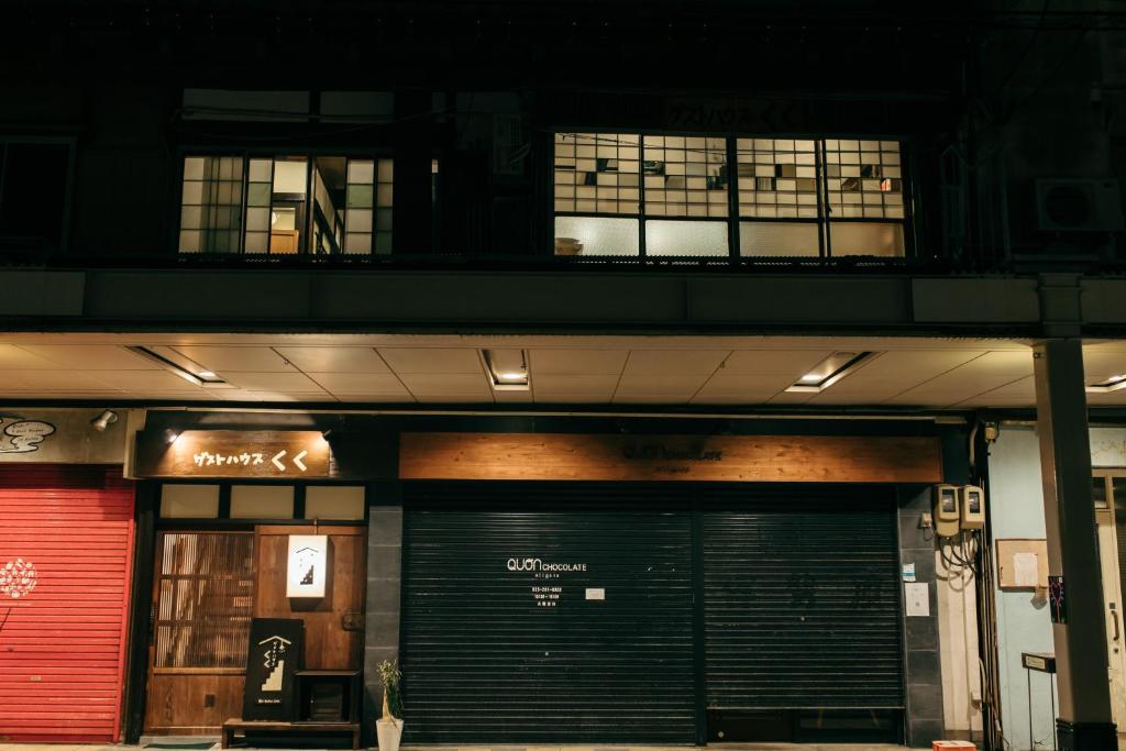 a building with a garage with a red door at Guest House KuKu in Niigata
