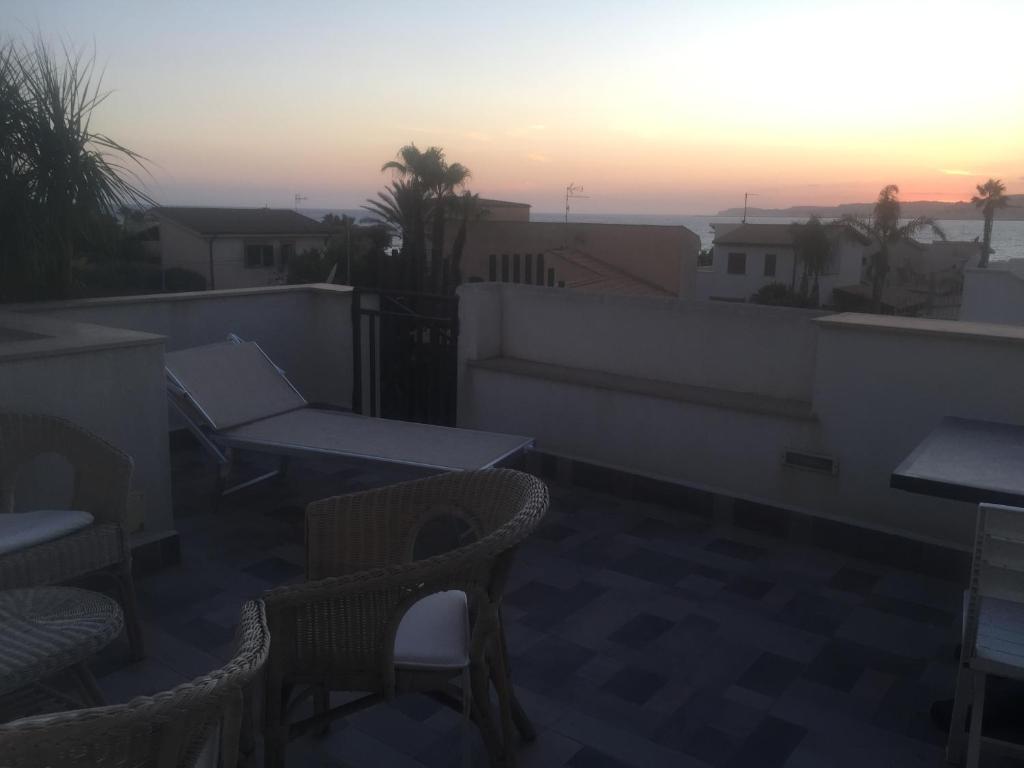 balcone con sedie, tavoli e tramonto di Casa vacanza Mansarda Sanleonina a Agrigento