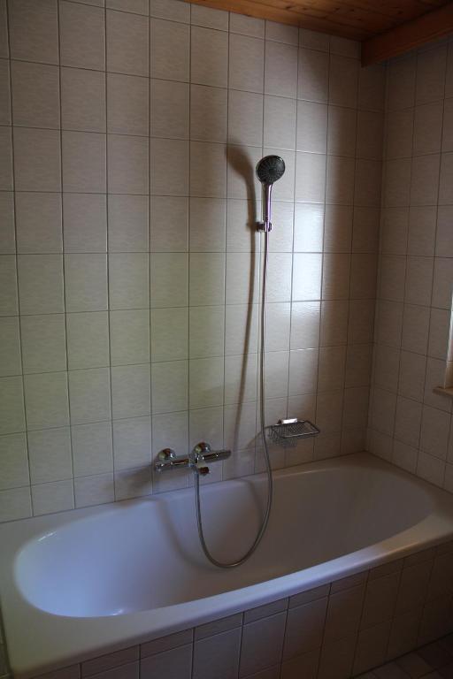 een badkuip met douche in een badkamer bij Ferienwohnung in der Schoß in Schruns