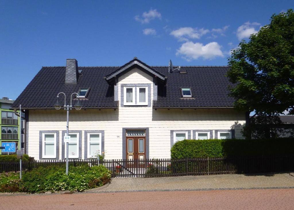 uma casa branca com um telhado preto em Haus Pia em Oberhof