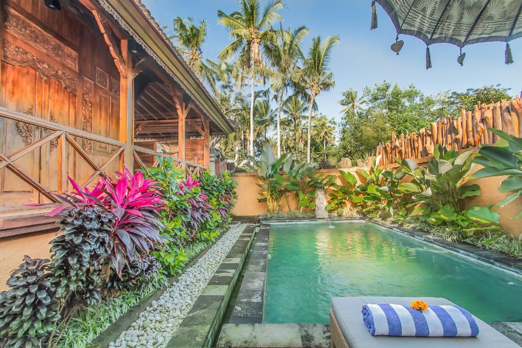 a swimming pool in front of a house at Green Zone Ubud Villas by Pramana Villas in Ubud