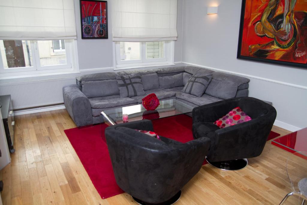 a living room with a couch and a red rug at Appartement Rennel in Nancy