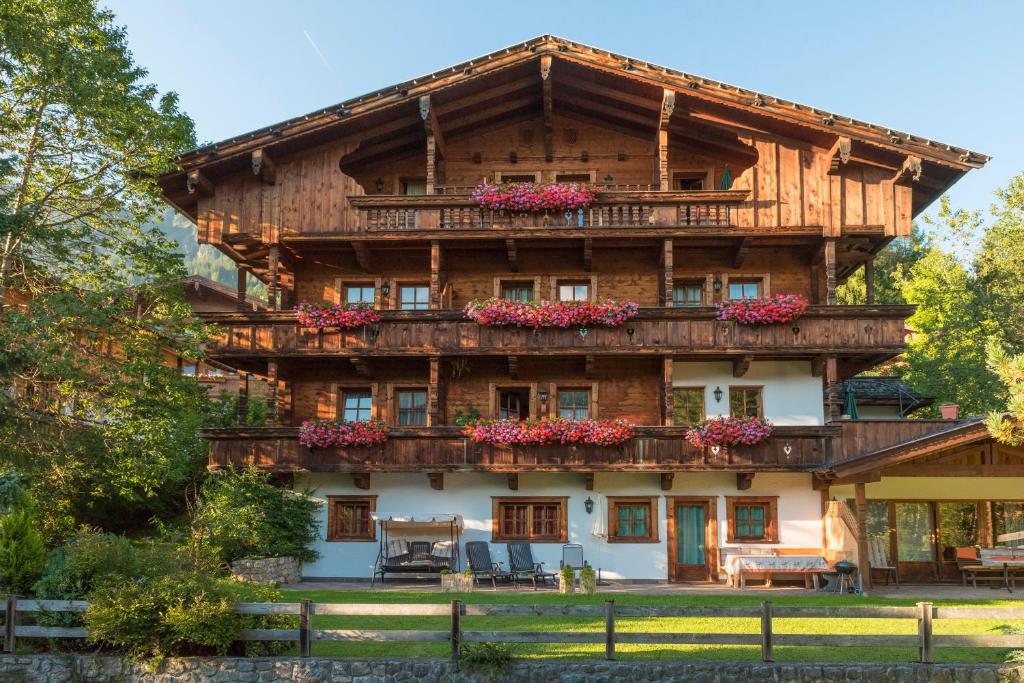ein großes Holzhaus mit Blumen auf dem Balkon in der Unterkunft Aparthaus Hubertus in Alpbach