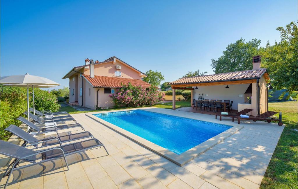 a swimming pool with chairs and a house at Awesome Home In Pazin With Outdoor Swimming Pool in Pazin