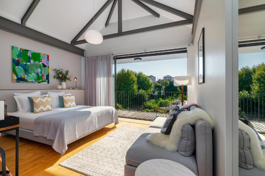 um quarto com 2 camas e uma sala de estar em Canto De Luz - Luxury Maison no Porto