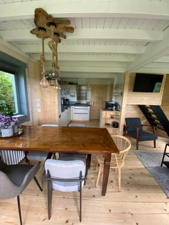 a dining room with a wooden table and chairs at Vakantiewoning Vrijburg in Schagerbrug