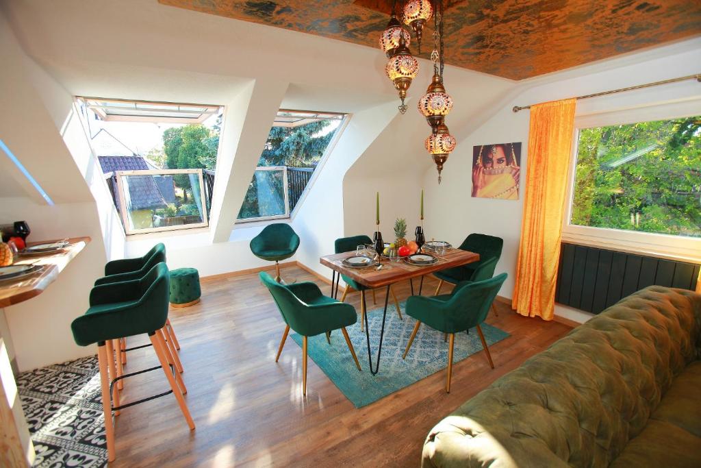 uma sala de estar com uma mesa e cadeiras verdes em 1001 Nacht Bodensee em Kressbronn am Bodensee