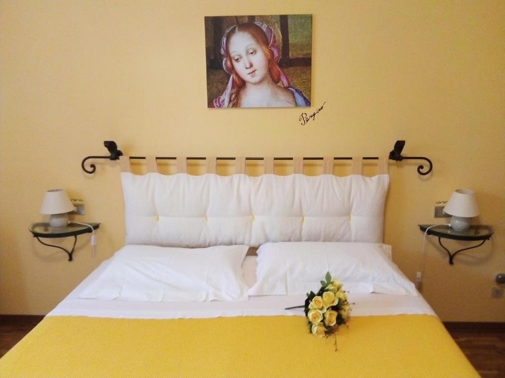 Schlafzimmer mit einem Bett mit Wandgemälde in der Unterkunft Il gelsomino del Perugino in Città della Pieve