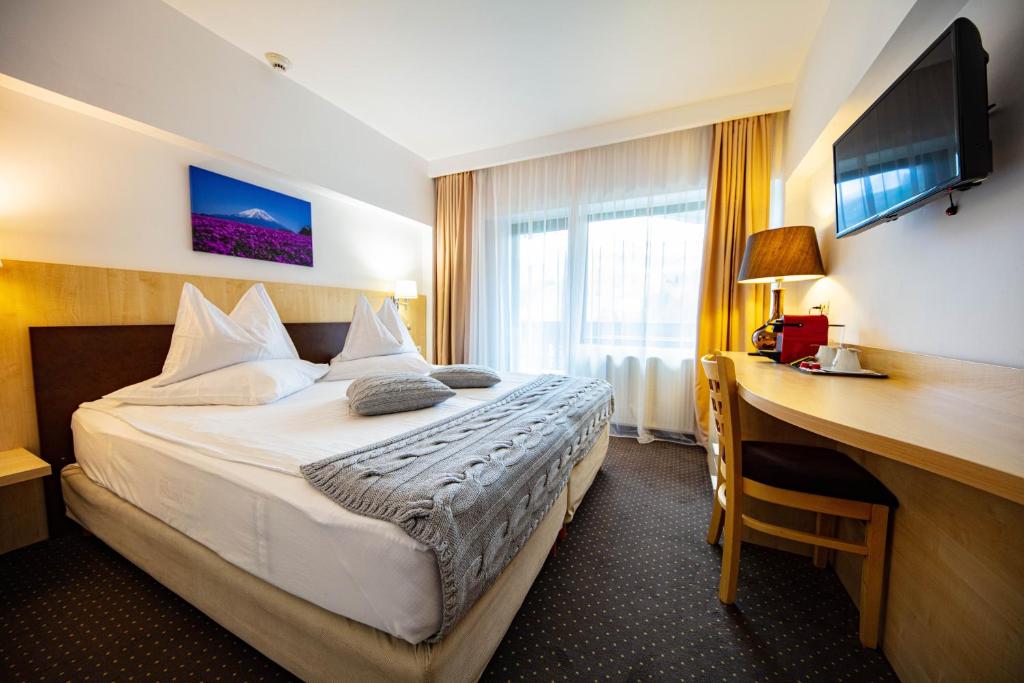 Un pat sau paturi într-o cameră la Hotel Pestera Patinoar & Spa