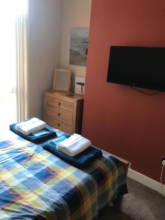 a bedroom with a bed and a flat screen tv at Richmond Luxury flat Fabulous location in Southend-on-Sea