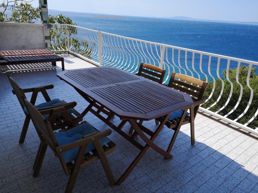 a picnic table and two chairs sitting on a balcony at Apartments Bassi in Stara Baška