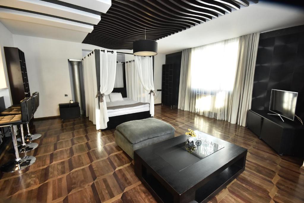 a living room with a couch, coffee table and a fireplace at Boutique Hotel Medusa in Batumi