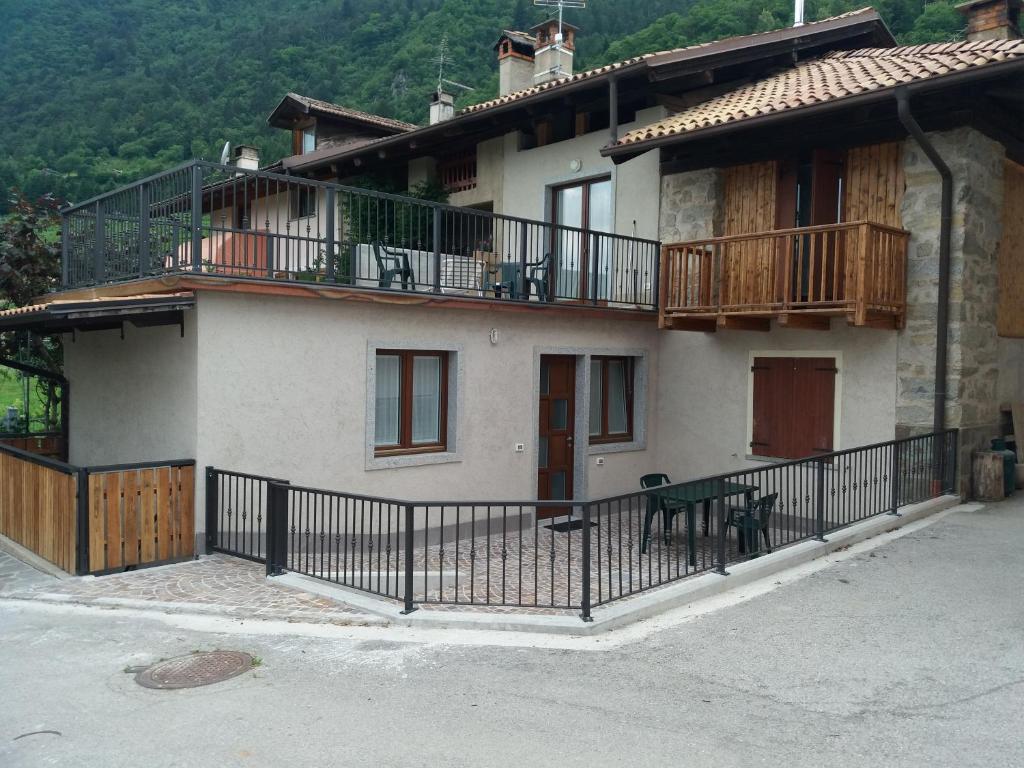 een huis met een balkon en een hek bij Appartamento Cillà in Comano Terme