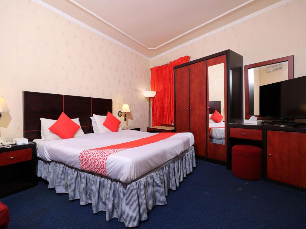 OYO 112 Semiramis Hotel في المنامة: غرفة فندقية بسرير كبير وتلفزيون بشاشة مسطحة
