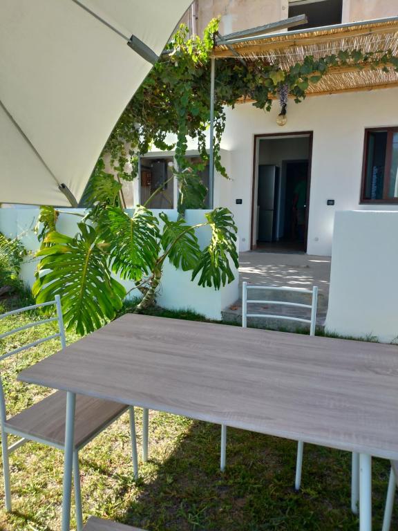 una mesa de madera y sillas frente a una casa en Perla Nera, en Leni