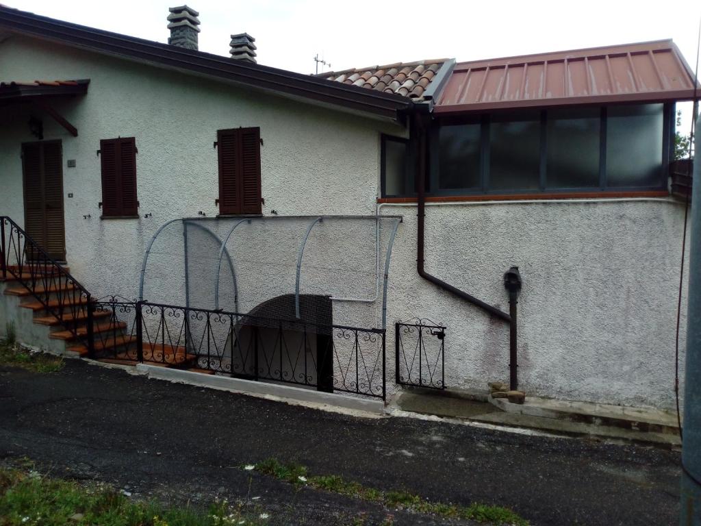 Casa blanca con porche y escalera en CASA ELISA (casa della nonna) en Montereggio
