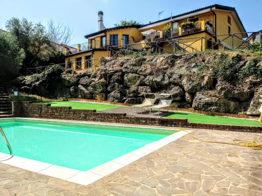 ein Haus auf einem felsigen Hügel mit Pool in der Unterkunft Appartamento in Villa in Frassine