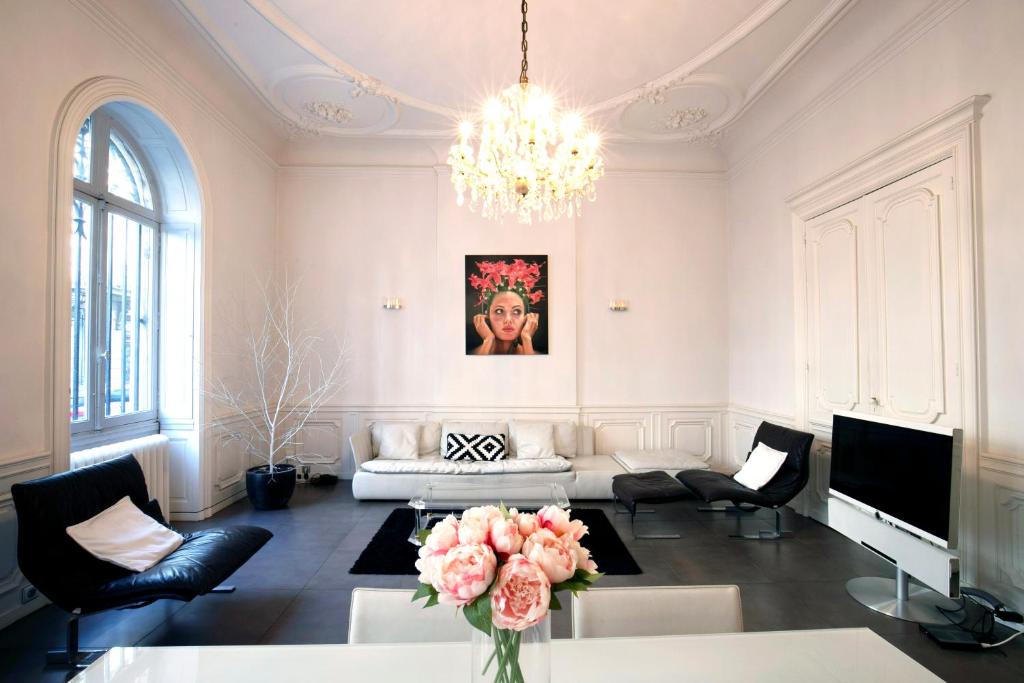 uma sala de estar com um sofá e um lustre em Bordeaux City Gardens em Bordeaux