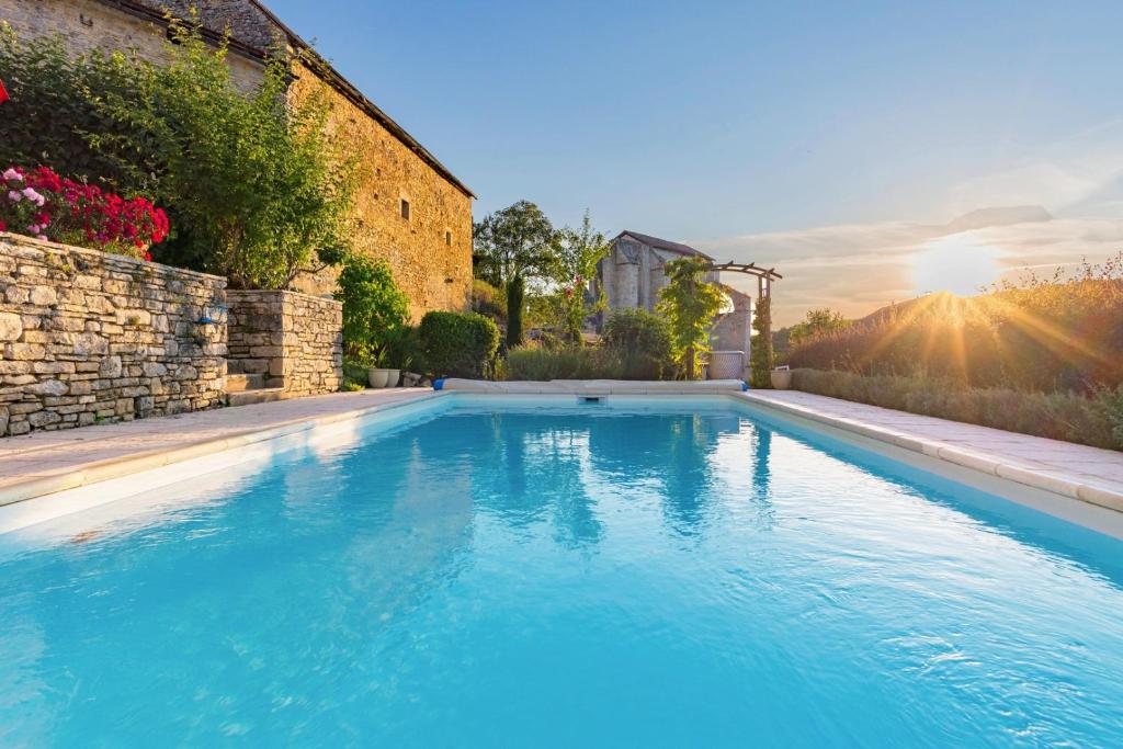 a large blue swimming pool next to a building at La Baraka in Léobard