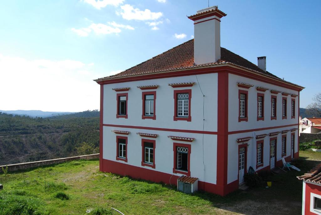 um pequeno edifício vermelho e branco numa colina em Prédio na Amêndoa em Amêndoa