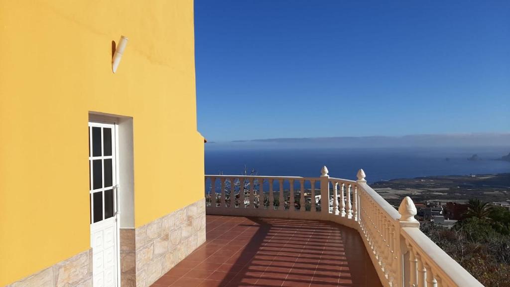 a yellow building with a balcony with a view of the ocean at Vista Guapa in Frontera