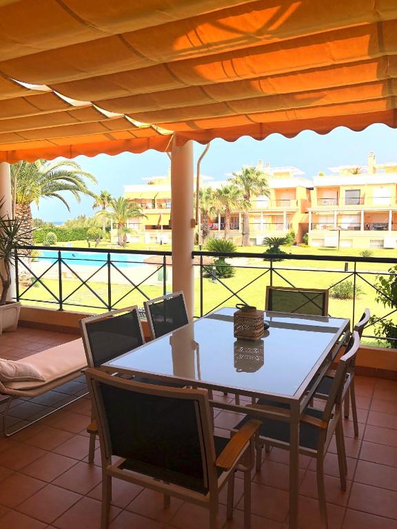 a table and chairs on a patio with a view of the water at Apartamento Casas del Mar in Oliva