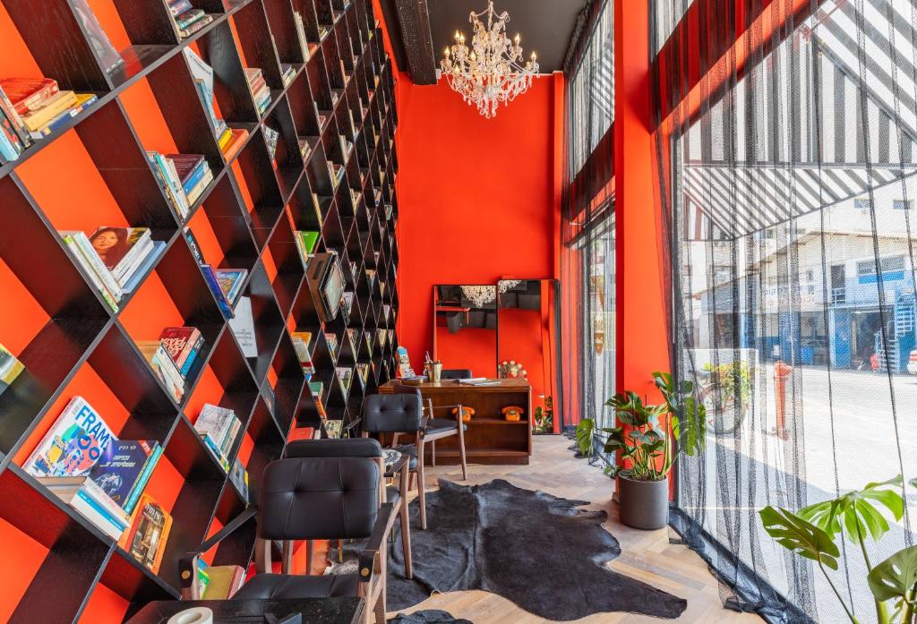 un ufficio con una parete arancione e librerie di Dave Downtown, a member of Brown Hotels a Tel Aviv