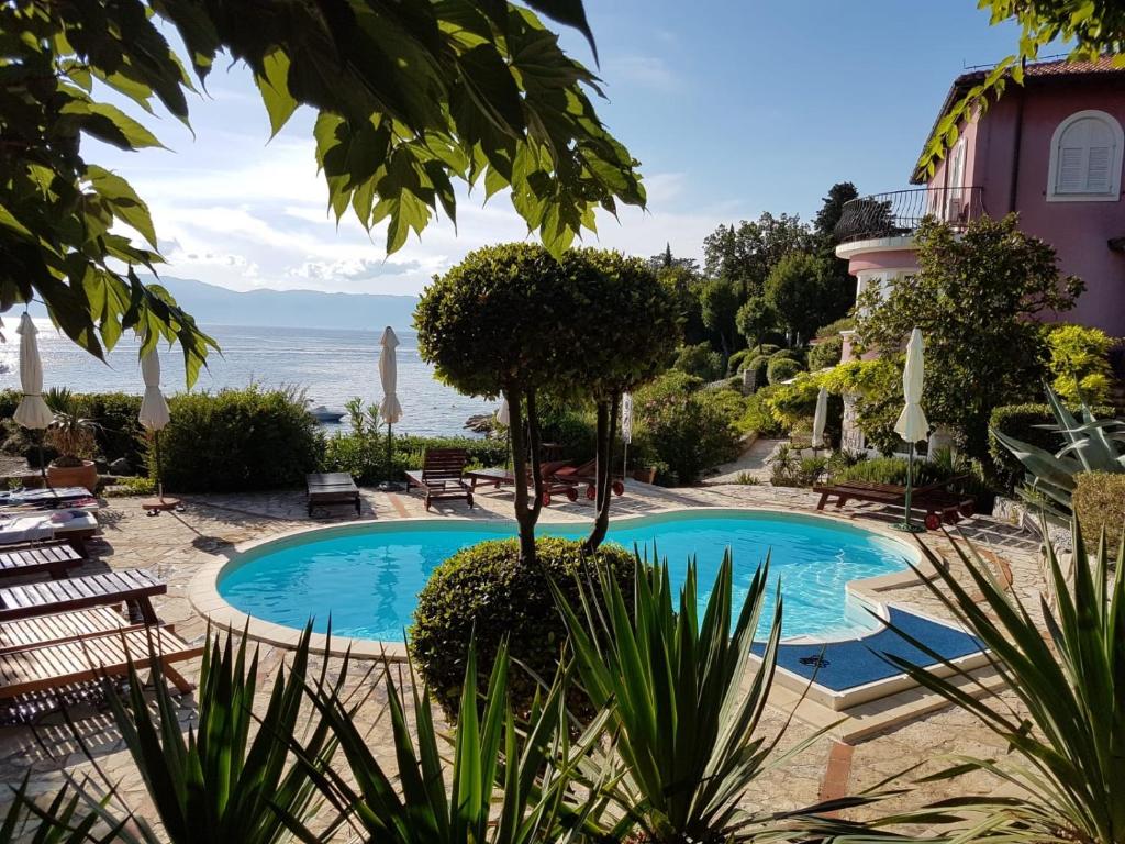a swimming pool with a view of the ocean at Apartments Villa Dora in Kraljevica
