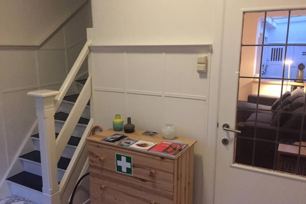 een kamer met een trap en een tafel en een trap bij Cosy little house in Brugge