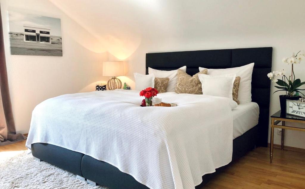 RS Apartment Baden-Baden في بادن بادن: غرفة نوم بسرير ابيض كبير عليها ورد