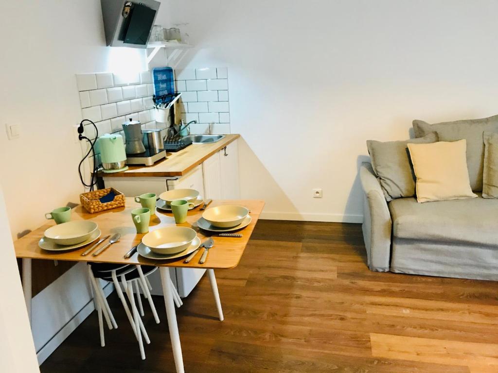 a small kitchen with a table and a couch at Apartament z balkonem blisko plaży in Niechorze