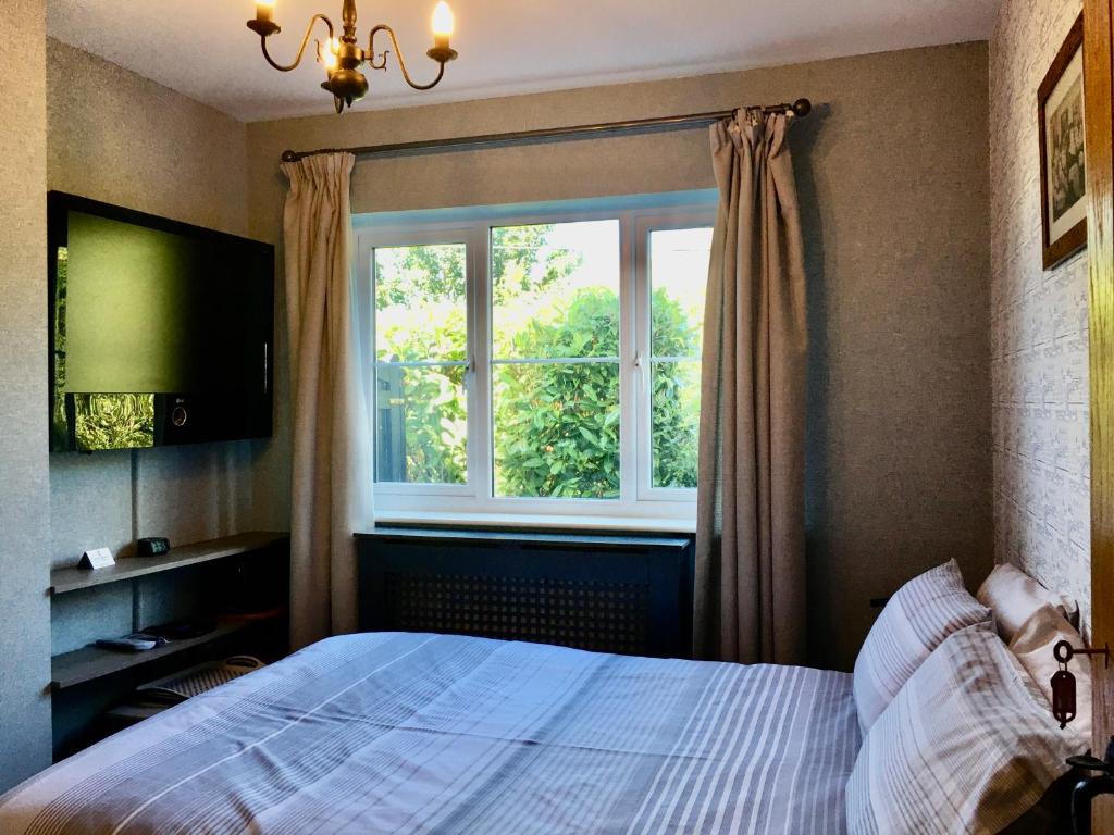 Schlafzimmer mit einem Bett und einem Fenster in der Unterkunft Woodbriar in Conwy