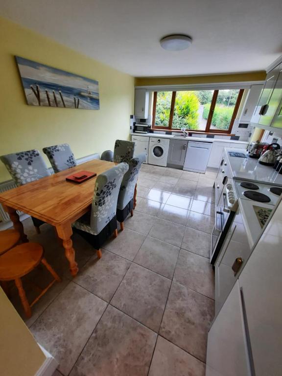 a kitchen and dining room with a wooden table and chairs at Lovely ballina townhouse in Ballina